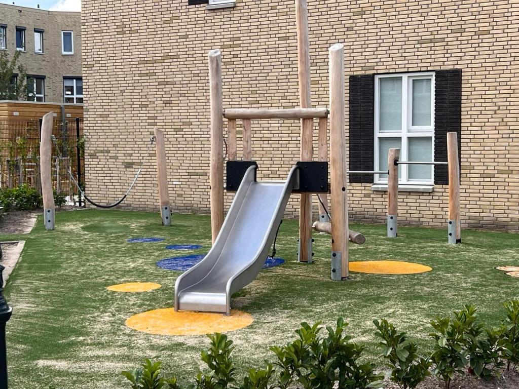a playground with a slide in front of a building at BB aan de Zuyderzee in Bunschoten