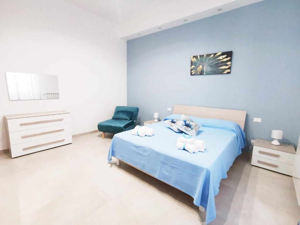 1 dormitorio azul con 1 cama y 1 silla en Casa Vin, en Massafra