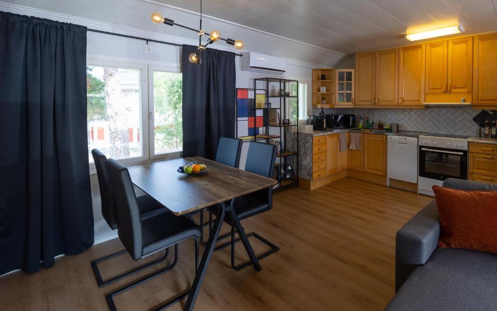 a kitchen and living room with a wooden table and chairs at Sleep Inn in Jomala