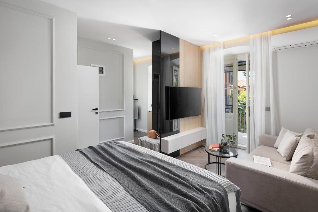 um quarto com uma cama, um sofá e uma televisão em Oia Room em Labin