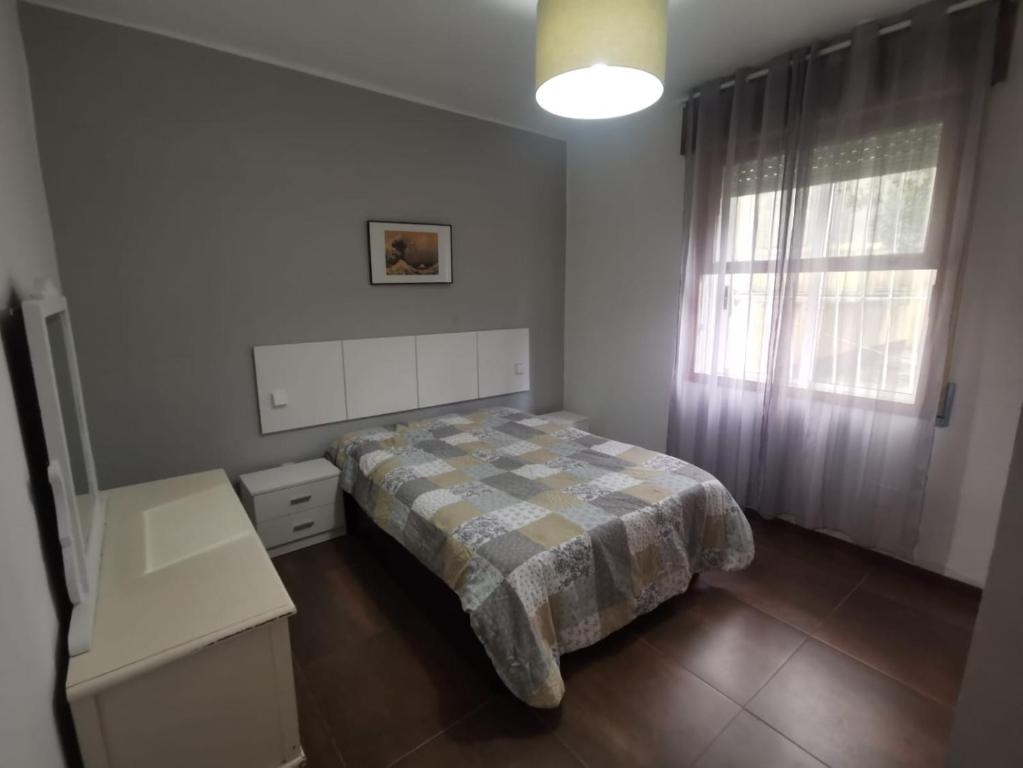 een kleine slaapkamer met een bed en een raam bij ACOGEDOR Y LUMINOSO PISO CÉNTRICO in Vigo