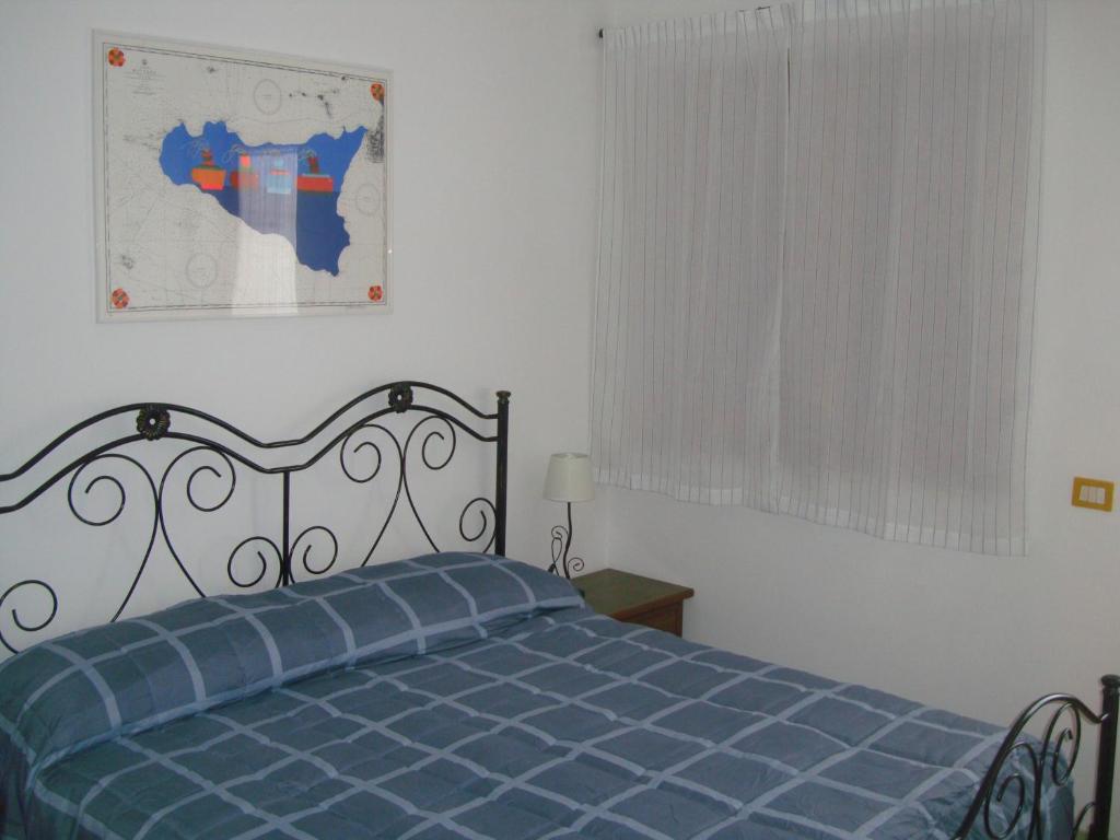 a bedroom with a blue bed and a window at Aurora e Andrea San Vito lo Capo in San Vito lo Capo