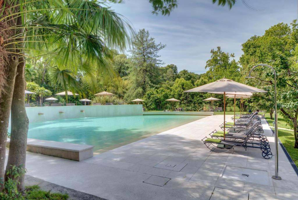 basen z leżakami i parasolem w obiekcie Rambaldi Apartments Casa nr 7 w mieście Bardolino