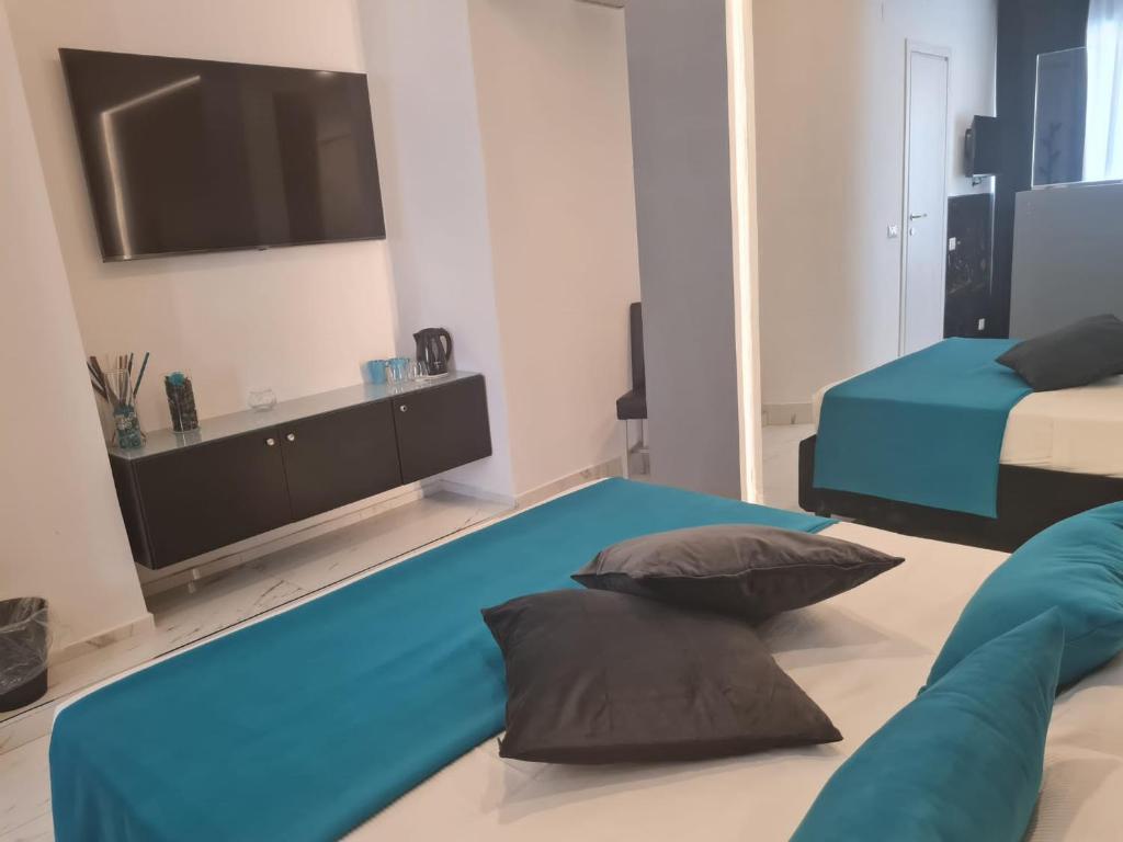 a bedroom with two beds and a flat screen tv at Maliziusella in Naples