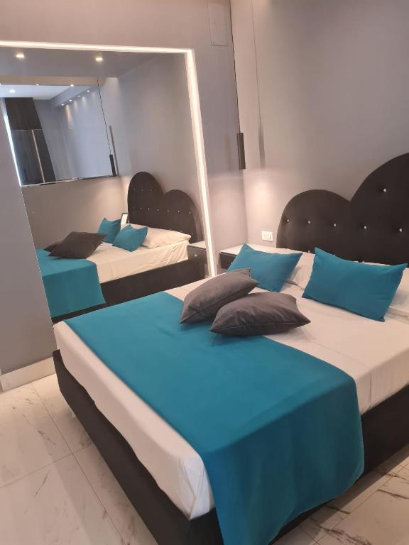 two beds in a room with blue and white at Maliziusella in Naples