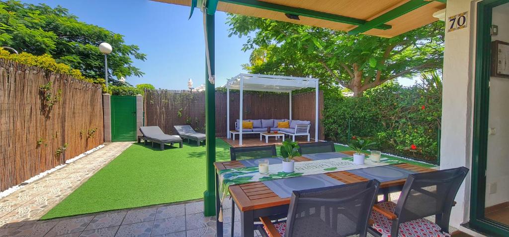 un patio con una mesa y sillas en el césped en Bungalows Playa Flor, Campo Internacional, Maspalomas., en Maspalomas