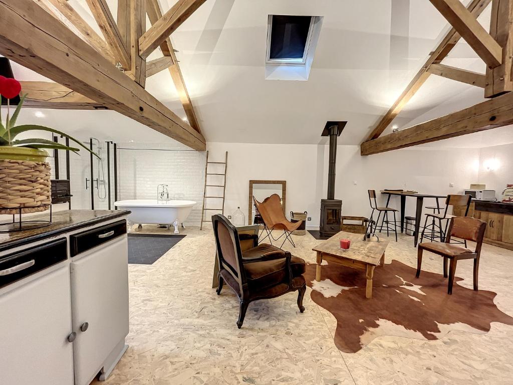 a kitchen and living room with a tub and a table at Magnifique et confortable loft in Marlieux