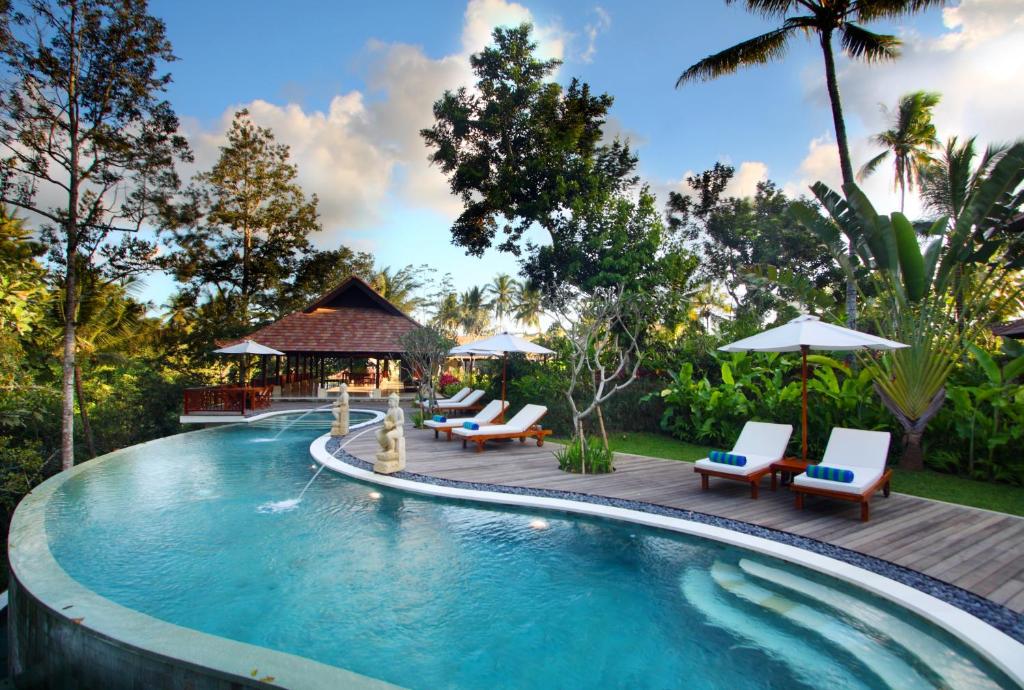 - une piscine dans un complexe avec des chaises et un kiosque dans l'établissement BeingSattvaa Luxury Ubud - CHSE Certified, à Ubud