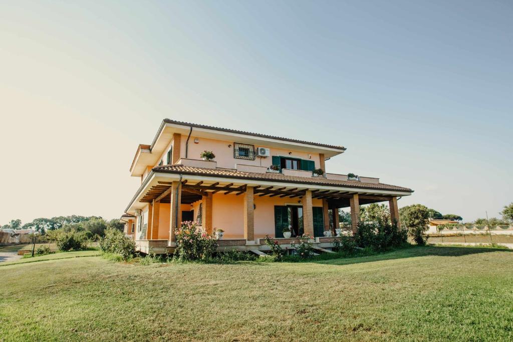 ein Haus mit einem großen Feld davor in der Unterkunft Bed and Breakfast Villa Romano in Anzio