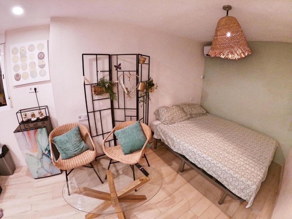 a room with a bed and two chairs and a table at Cala Nova Studios, Vinaròs in Vinarós