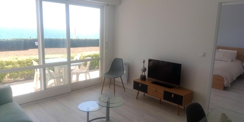 Televízia a/alebo spoločenská miestnosť v ubytovaní Appt entier Résidence de la Plage Vue Mer Port Navalo