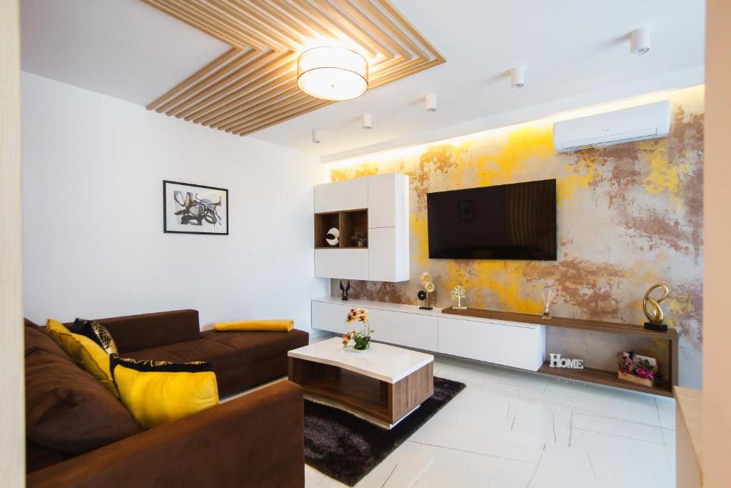 a living room with a couch and a tv at Romantic getaway at West Residence in Oradea