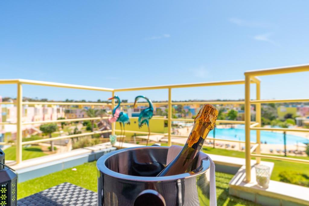 a bottle of wine in a cup on a balcony with a view at Lovely LM Penthouse in Albufeira