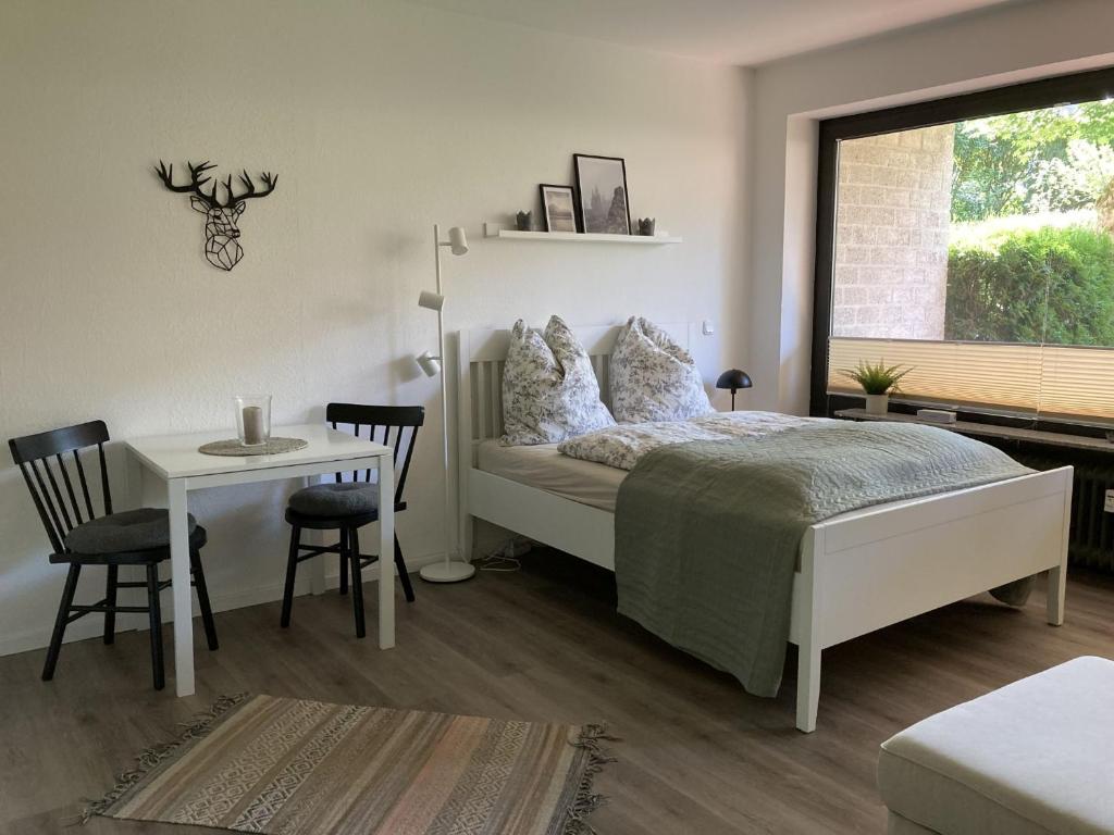 ein Schlafzimmer mit einem Bett und einem Tisch und einem Fenster in der Unterkunft Fewo Lotte in Goslar