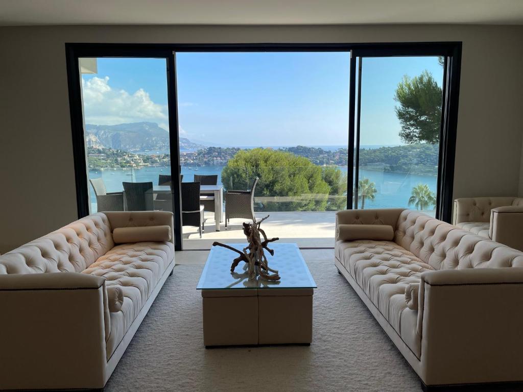 una sala de estar con sofás y una mesa con vistas. en Villa LA ALEGRIA en Niza
