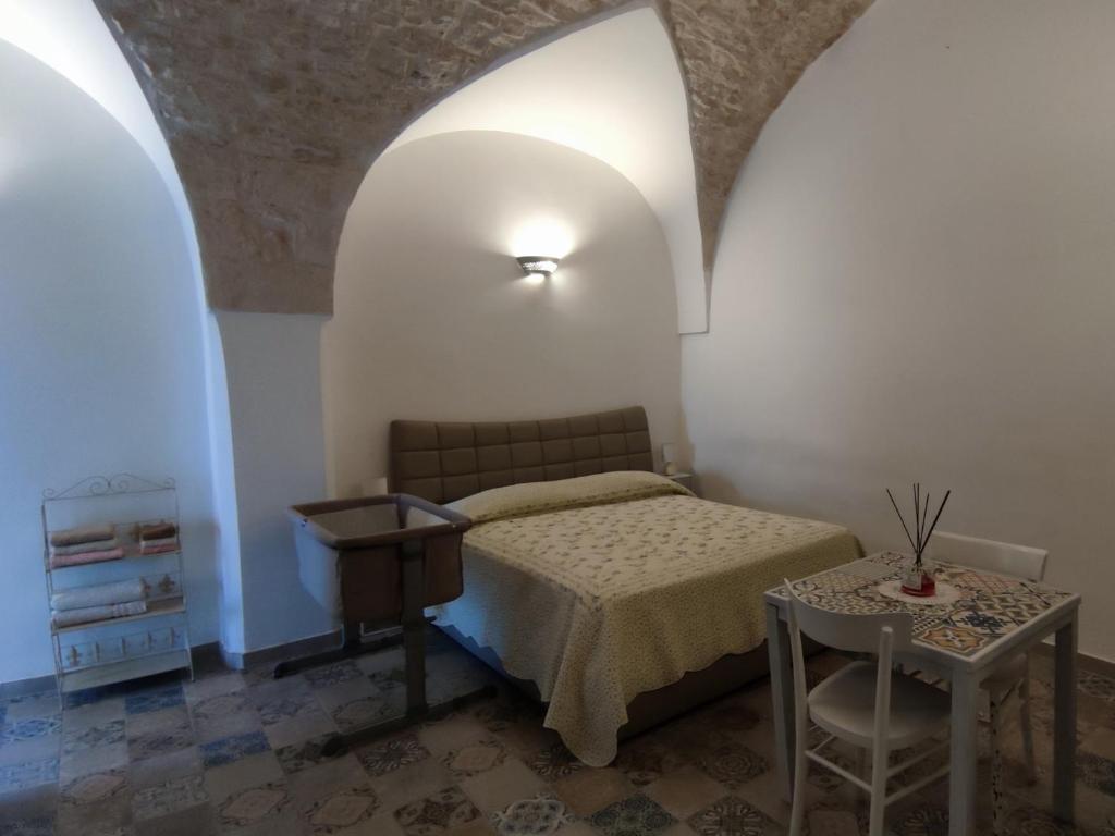 Schlafzimmer mit einem Bett und einem Tisch in der Unterkunft Maison Matilde in Ceglie Messapica