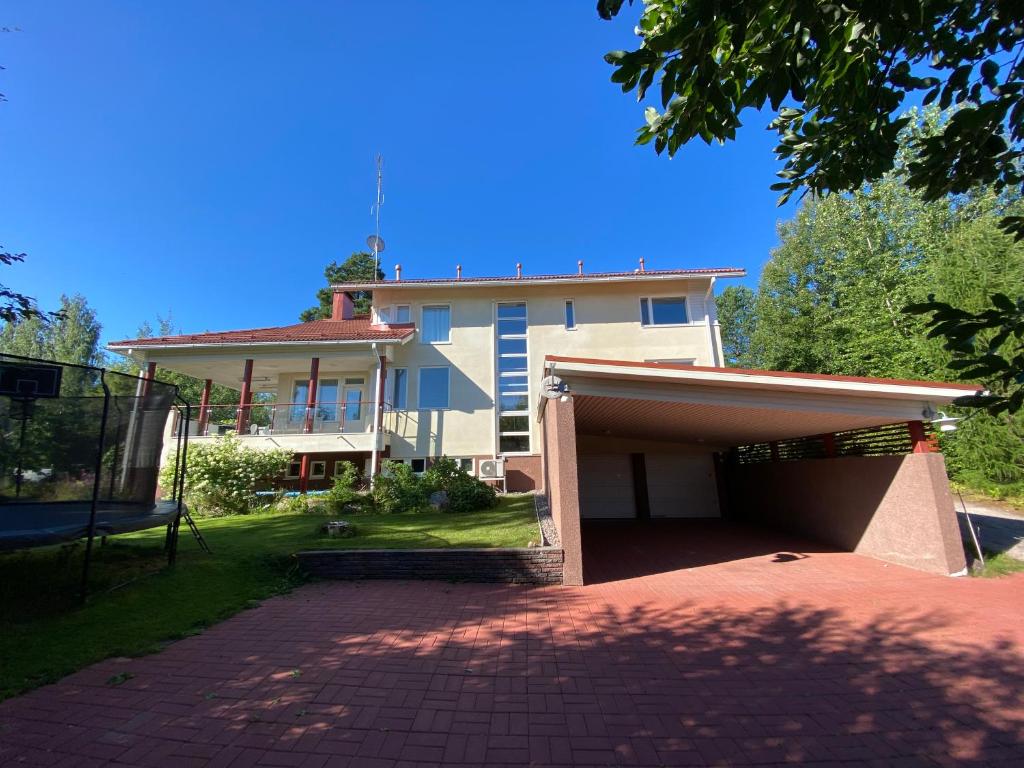 una casa grande con un garaje delante en Grand Villa Kivistö near Helsinki airport en Vantaa