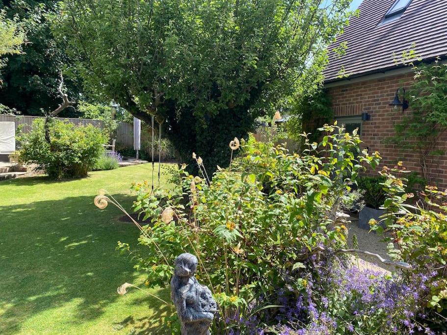 a garden with a statue in the middle of a yard at Detached annex in centre of Woodstock, Cotswolds in Woodstock