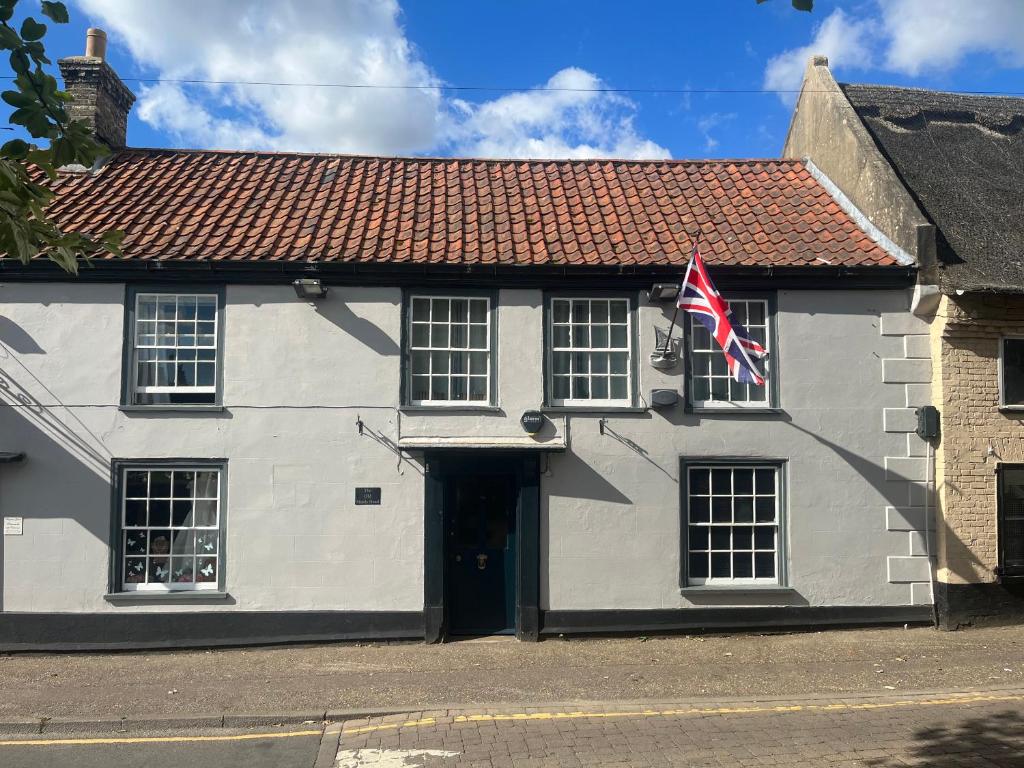 a white building with a flag in front of it at Remarkable 2-Bed Apartment in Norfolk Broads in Norwich