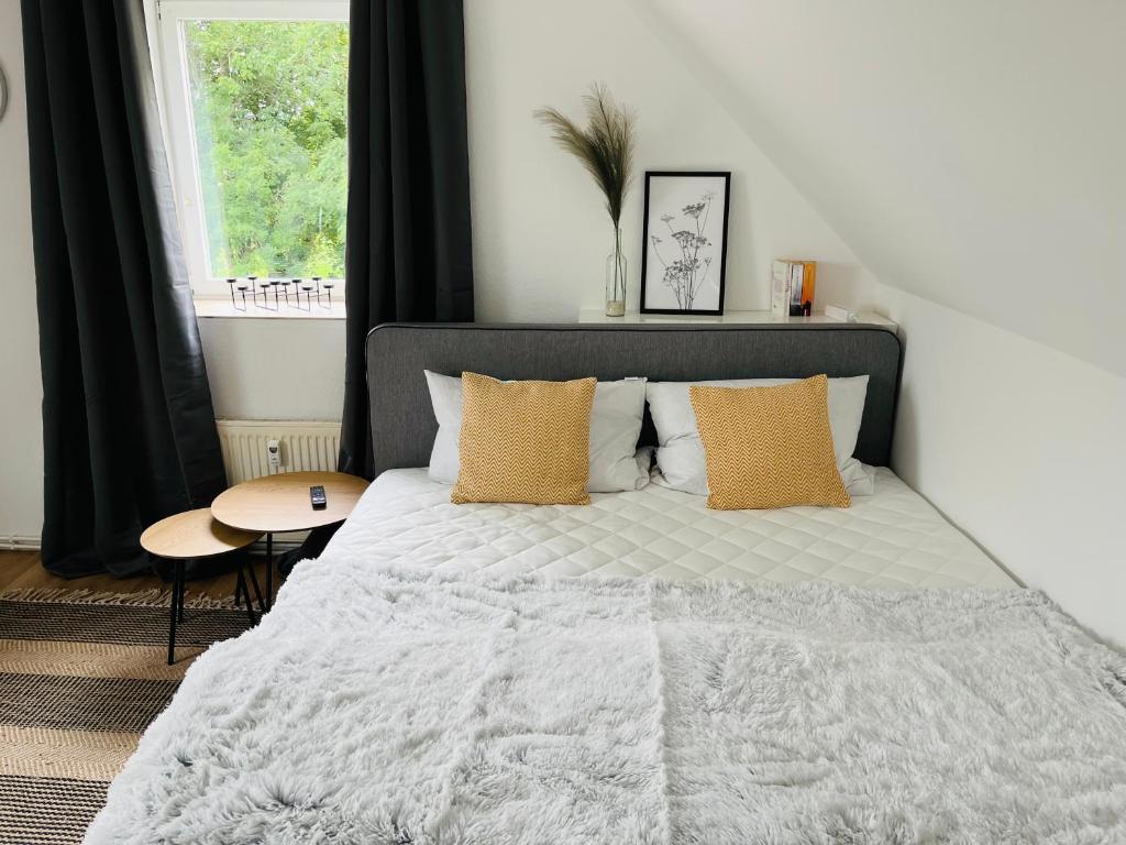 a bedroom with a bed and a table and a window at Deich Winde 9.1 in Dorum-Neufeld