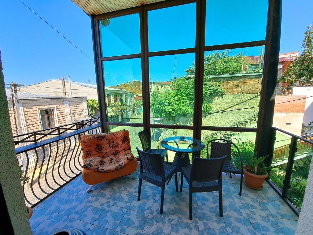 een kamer met een balkon met een tafel en stoelen bij Aisi2 in Koetaisi