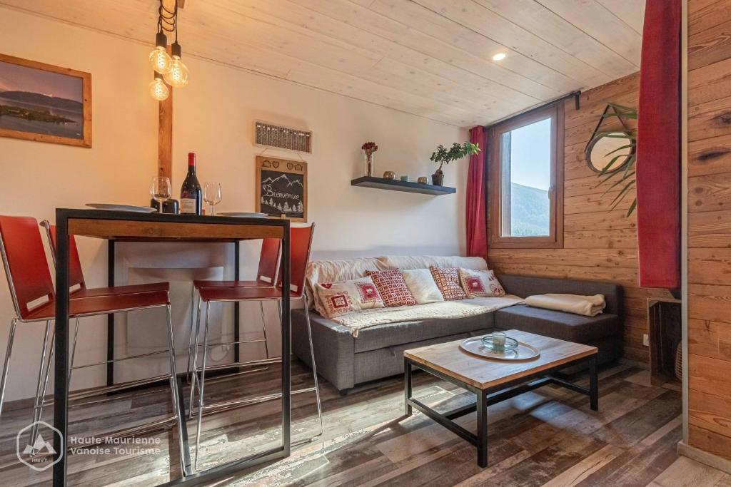 a living room with a couch and a table at Le Cocon de l'Arcelle in Lanslevillard