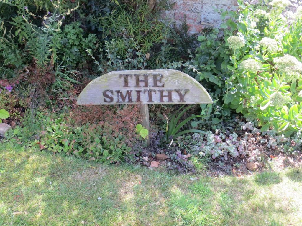 a sign that says the smithy in a garden at The Smithy in Snettisham