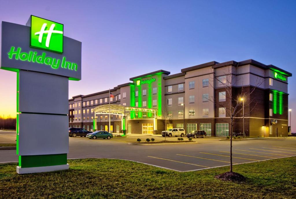 a building with a holiday inn sign in front of a parking lot at Holiday Inn - Erie, an IHG Hotel in Erie
