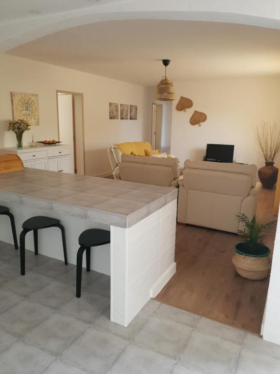 eine Küche und ein Wohnzimmer mit einem Tisch und Stühlen in der Unterkunft Monte das Flores Casa de Campo 