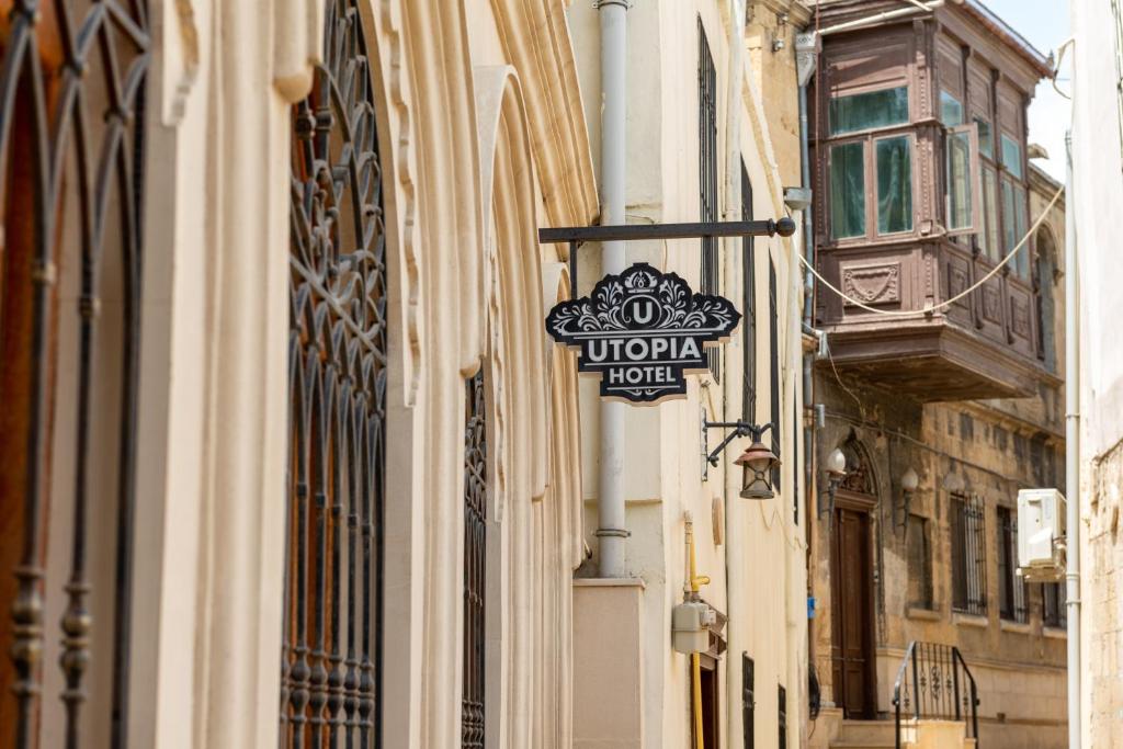 a sign for a hotel hanging on the side of a building at Utopia Hotel Baku in Baku