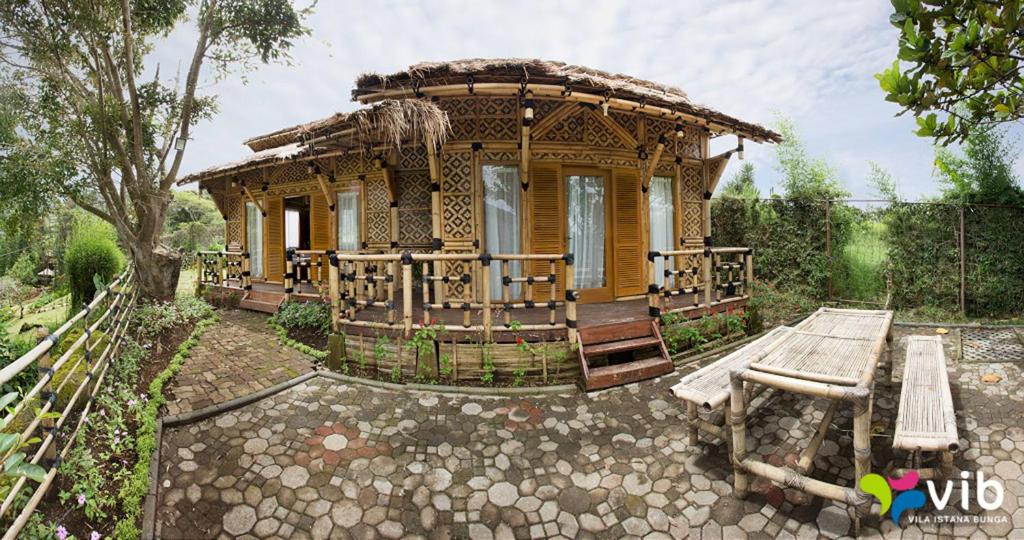 una piccola casa con una panchina davanti di Bamboo Village by Villa a Lembang