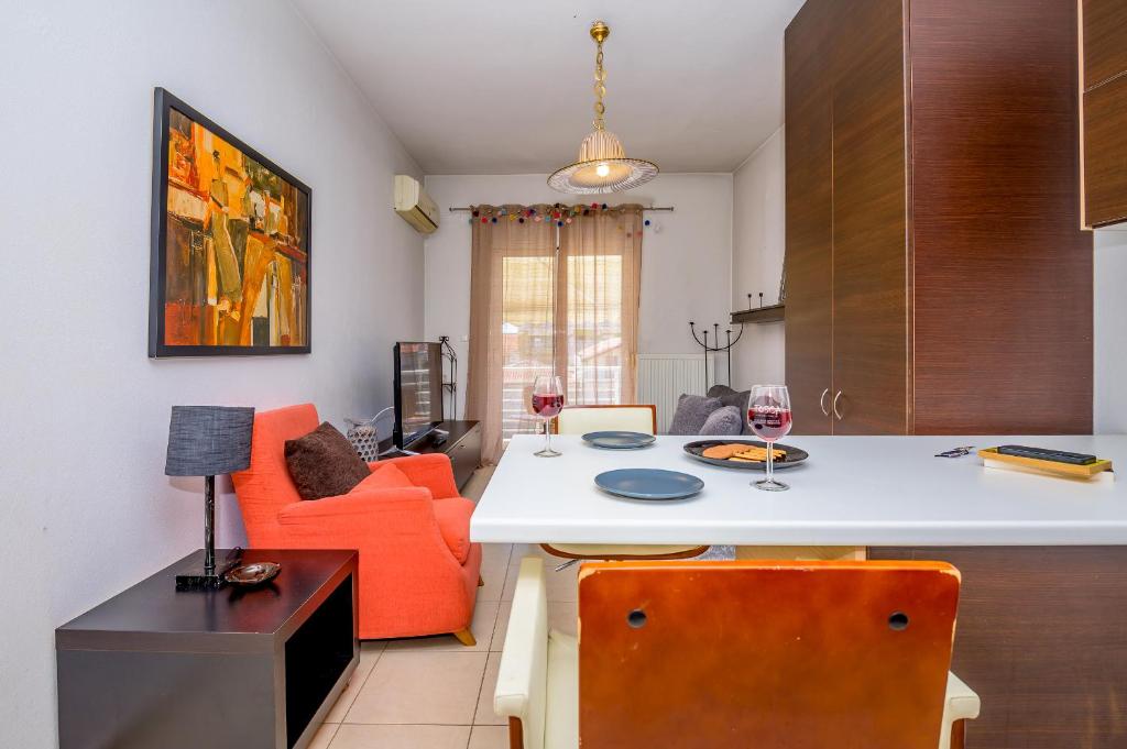 uma cozinha e sala de estar com um sofá laranja em cozy panta em Orestias