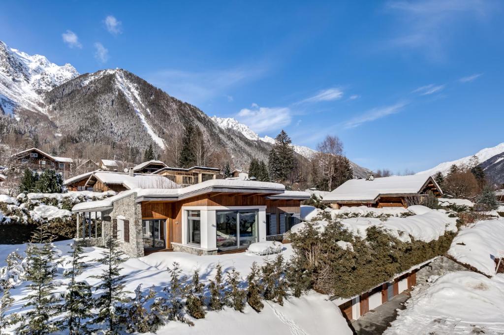 una casa en las montañas cubierta de nieve en Chalet Safari. Face au Mont-Blanc. en Chamonix-Mont-Blanc
