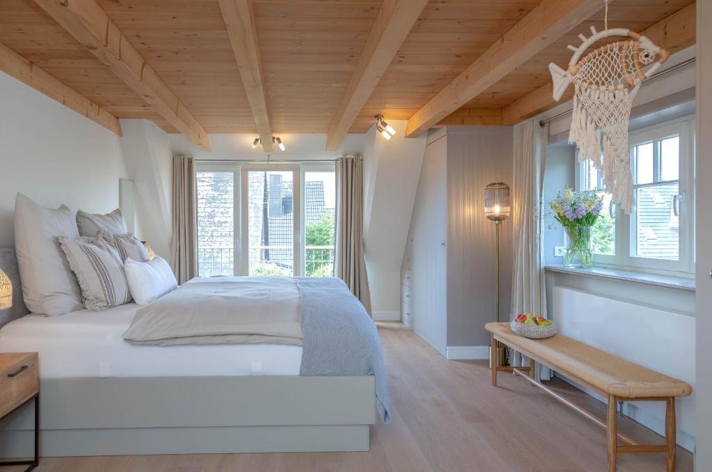 韋斯特蘭的住宿－Hüs im Glück，一间卧室设有一张大床和木制天花板