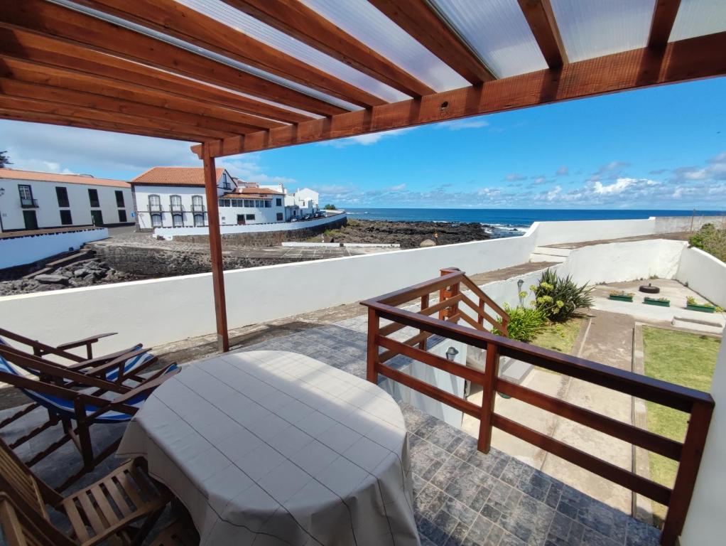a balcony with a table and chairs and a view of the ocean at Casa do Paúl in Santa Cruz da Graciosa