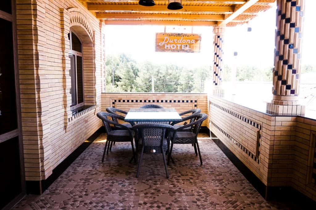 - une table et des chaises dans une chambre avec fenêtre dans l'établissement Durdona Guest House, à Samarcande