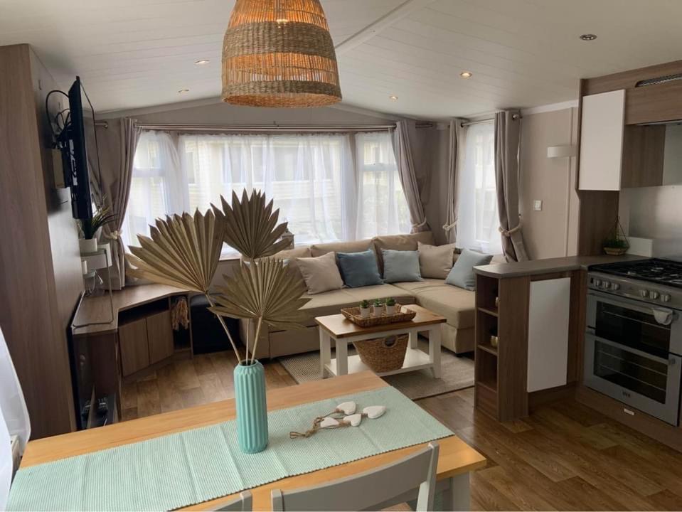 een keuken en een woonkamer met een bank en een tafel bij Cosy, coastal themed Holiday Home, Rockley Park, Poole, Dorset in Poole
