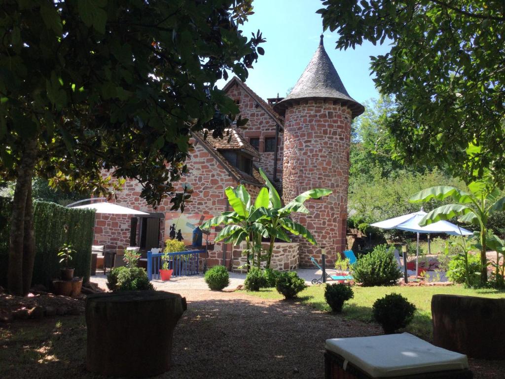 un bâtiment en briques avec une tour dans l'établissement Maison luxe Collonges la rouge,jakuzzi,clim,WIFI,piscine, à Collonges