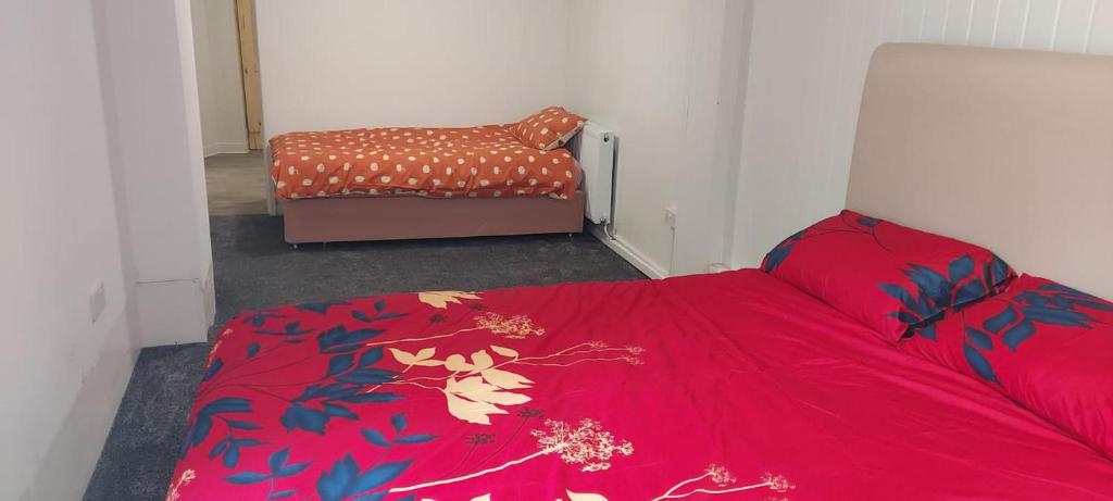 a bedroom with a red bed and a chair at Lovely 3-Bed Apartment in Parkgate Rotherham in Rotherham