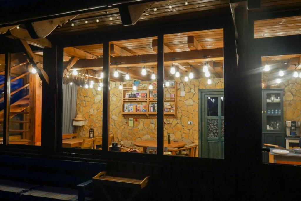 a view of a restaurant through a window at Rose Hip Hill Farm in Valea Tîrnei