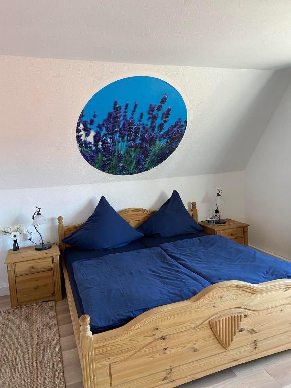 een slaapkamer met een groot houten bed met blauwe lakens bij Ferienhaus am Bergl in Mücka