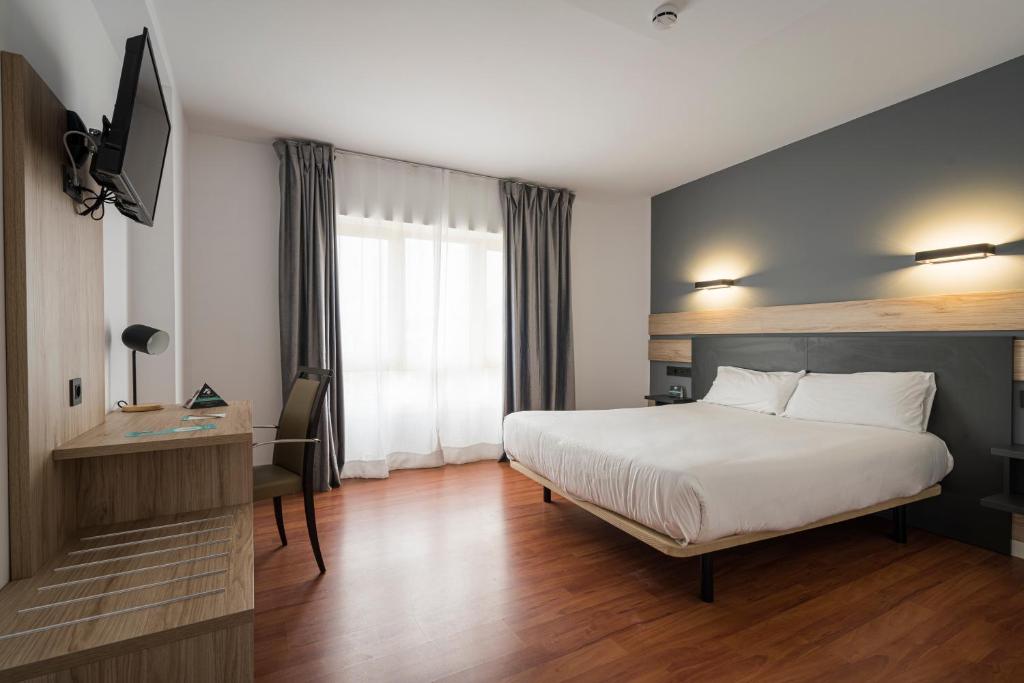 ヒホンにあるHotel Alda Centro Gijónのベッドとテレビが備わるホテルルームです。