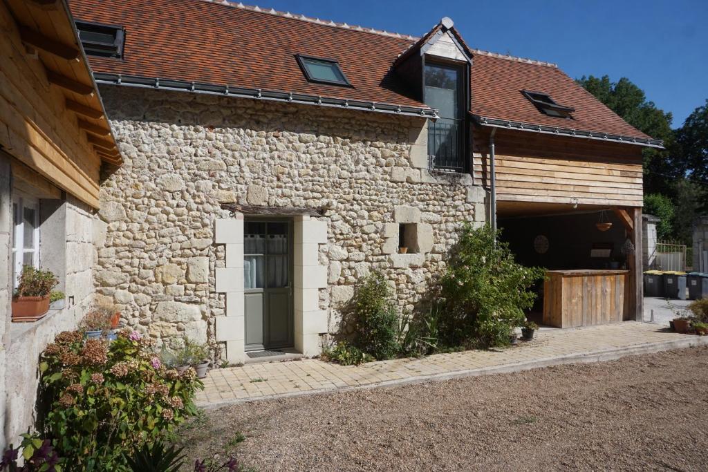 ein Steinhaus mit einer Garage und einer Scheune in der Unterkunft Le Gîte de Moquesouris in Nazelles