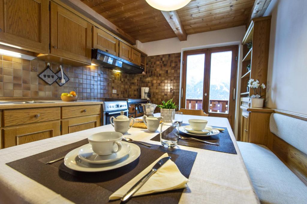 een keuken met een tafel met borden erop bij Panorama Apartment Pizaut in Ortisei