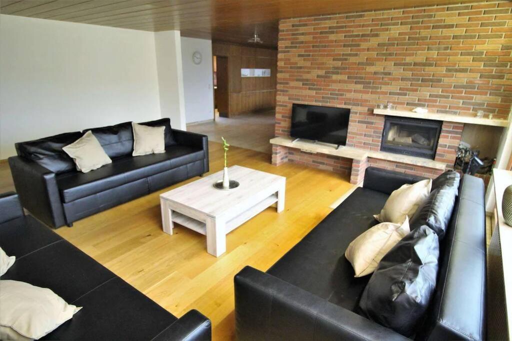 sala de estar con sofá y chimenea en Schöne, große Wohnung mit Parkplatz und Wlan, 