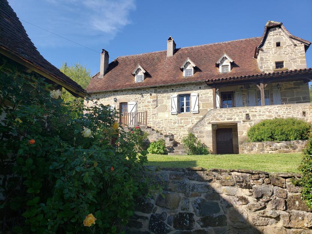 een oud stenen huis met een stenen pad ervoor bij Villa La Cayrouse Piscine Tennis Boulodrome in Le Bouyssou