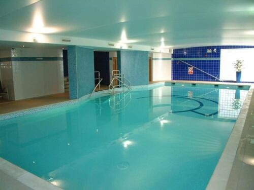 a large swimming pool with a large blue pool at Century Wharf by Urban Space in Cardiff