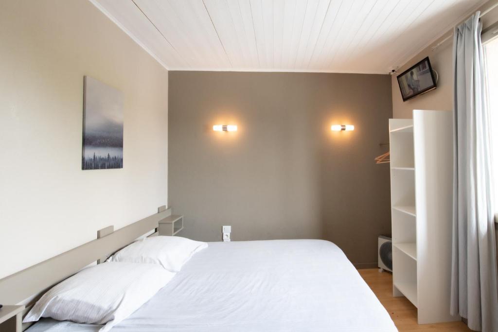 um quarto com uma cama branca e duas luzes na parede em Chez Jostel - Chambre 4 em Genay