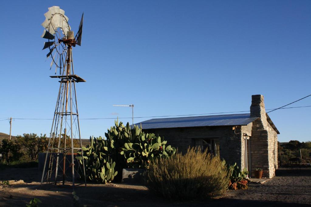 an old windmill in front of a house at Die Stal in Sutherland