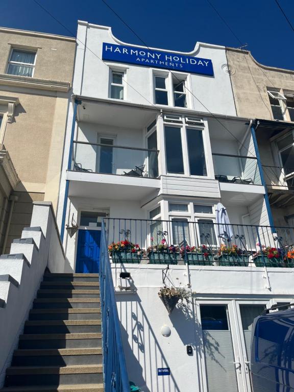 a white building with a sign on it at Harmony Apartments in Weston-super-Mare